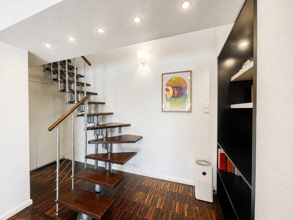 Offene Treppe mit Holzstufen und Metallgeländer